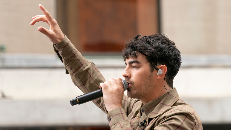 Joe Jonas singing arm up