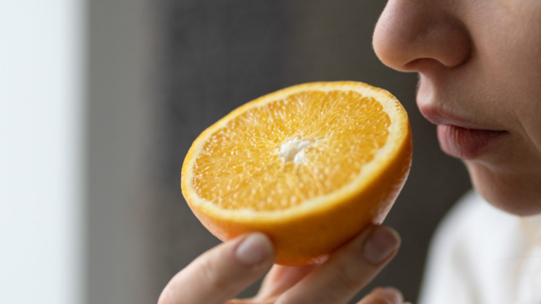 woman smelling an orange