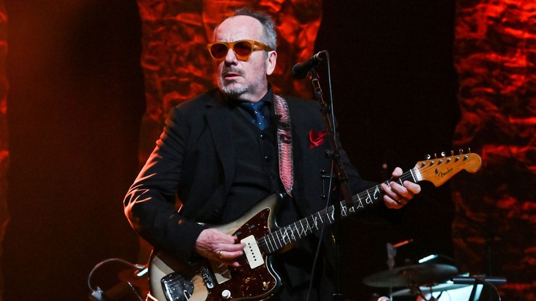 Elvis Costello playing guitar onstage