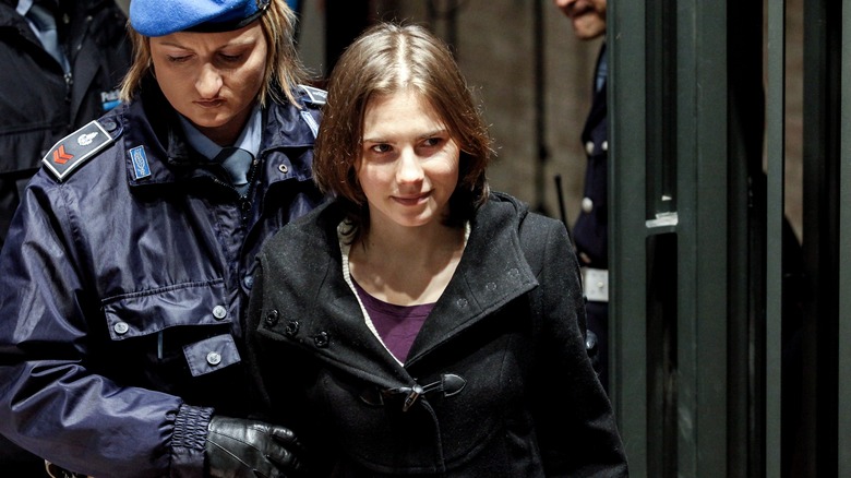 Amanda Knox being escorted into court by an officer