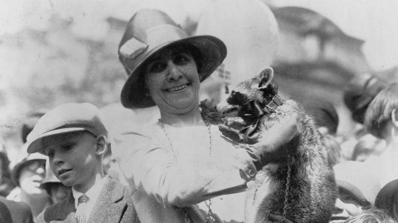 Grace Coolidge holding a raccoon
