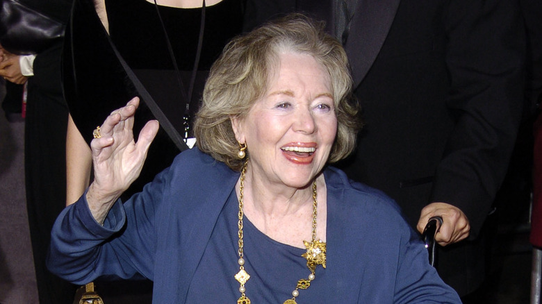 Glynis Johns smiling hand raised at event