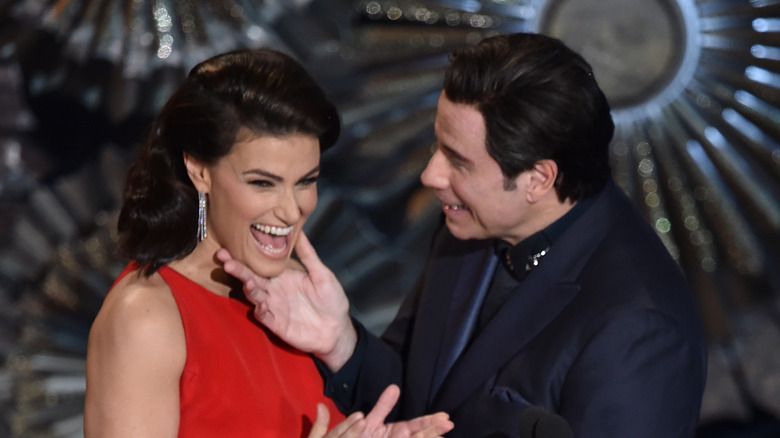 Travolta touching Idina Menzel's face