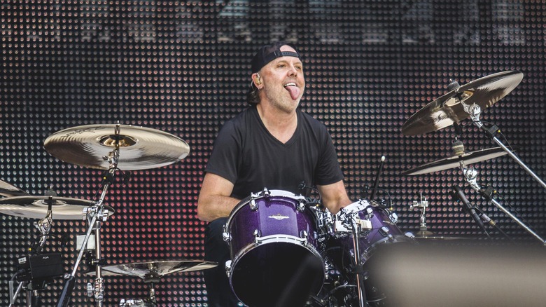 Lars Ulrich playing drums with tongue out
