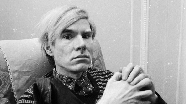 Andy Warhol with hands folded