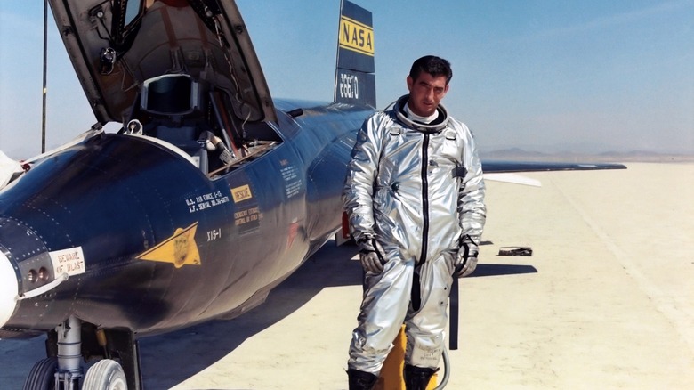 Michael J. Adams in a flight suit next to a NASA jet