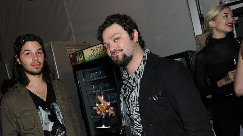 Bam Margera holding a glass of wine