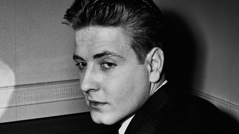 Eddie Cochran brooding in the corner of a room, black and white photo