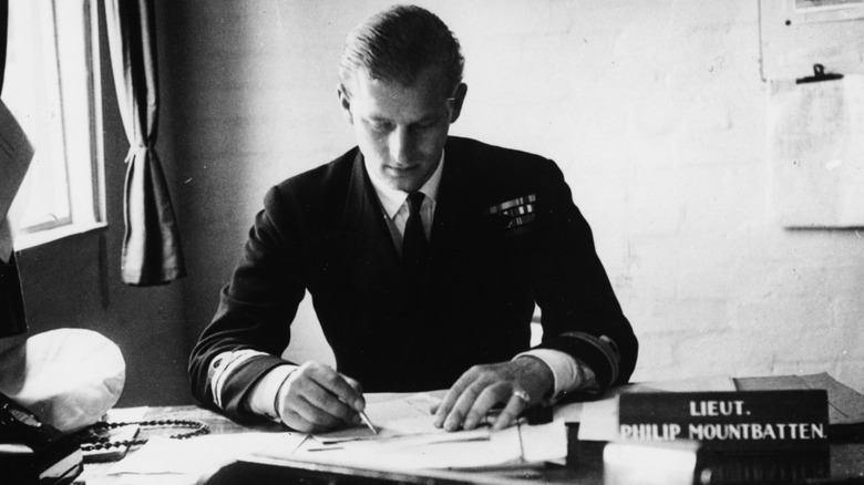 Prince Philip writing at desk before marriage to Elizabeth II