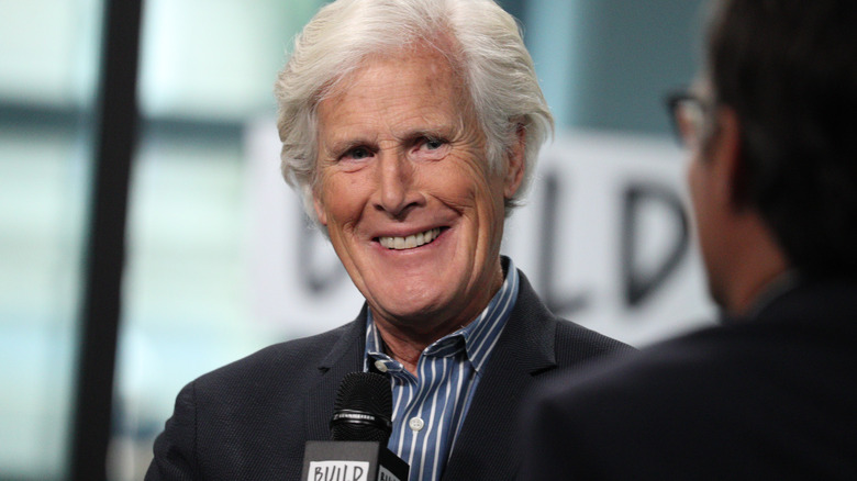 Keith Morrison smiling in suit holding microphone