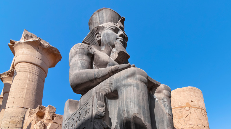 A statue of Rameses II looming over ruins