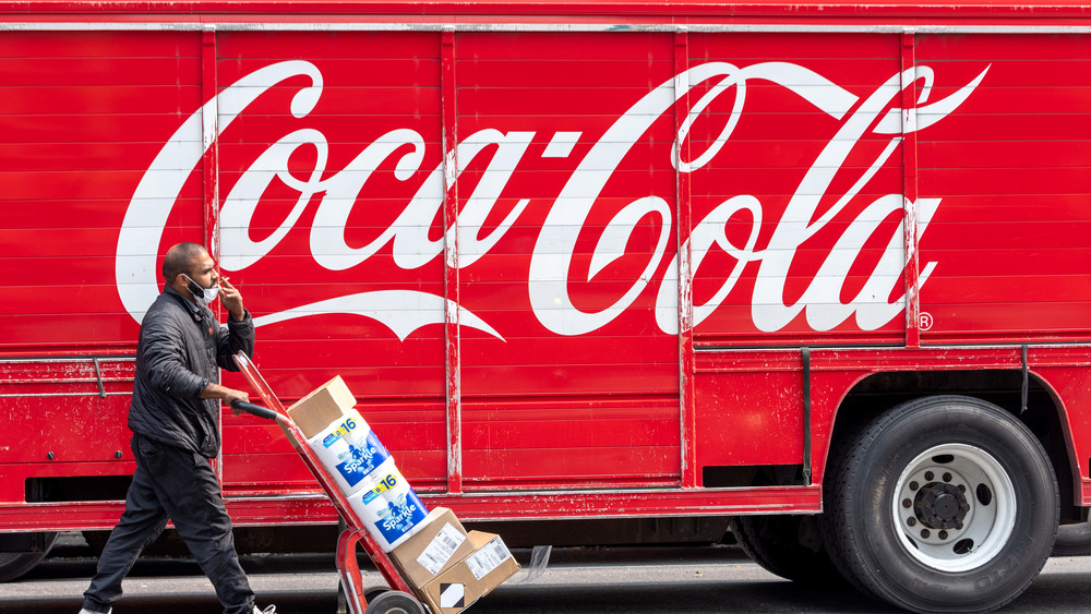 A worker unloading a Coca-Cola truck