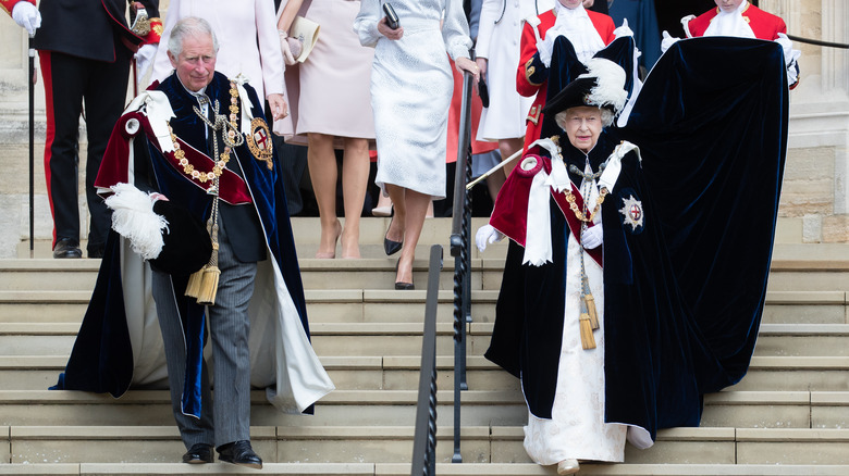 Queen Elizabeth and Prince Charles walking down steps