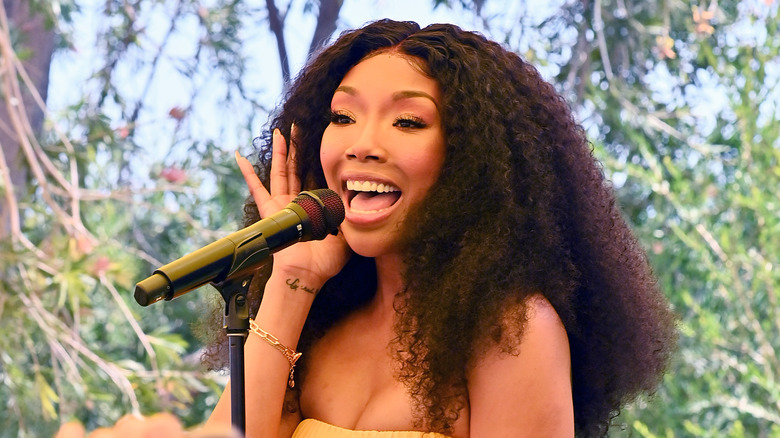 Brandy Norwood singing into a microphone