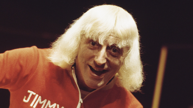 Jimmy Savile smiling and staring ahead