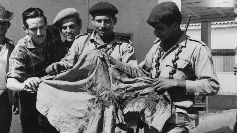 Cuban soldiers holding bloody shirt