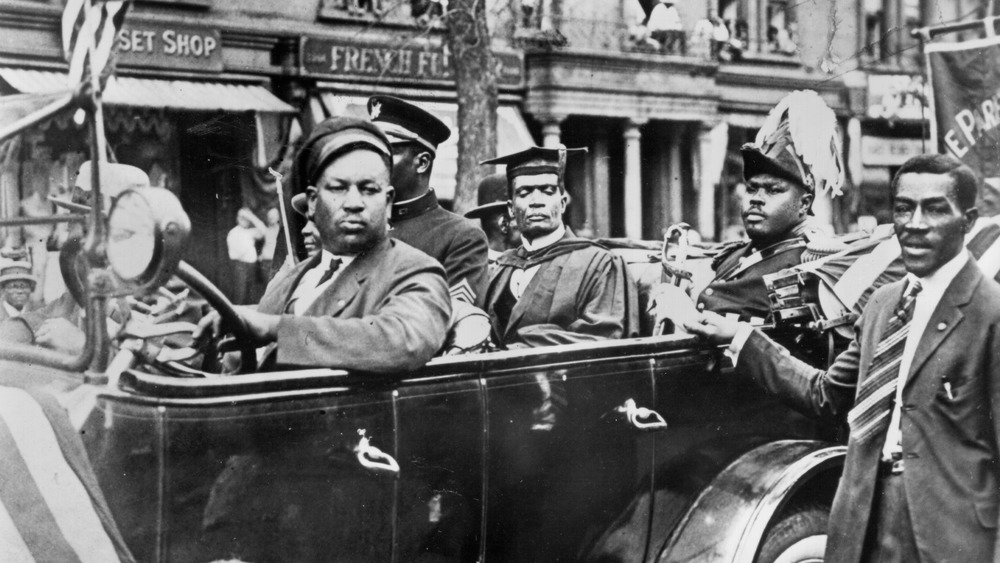 1920: Marcus Mosiah Garvey, Jr., National Hero of Jamaica and leader of the Back to Africa movement sits in the back of a car in a parade through Harlem circa 1920 in New York City,