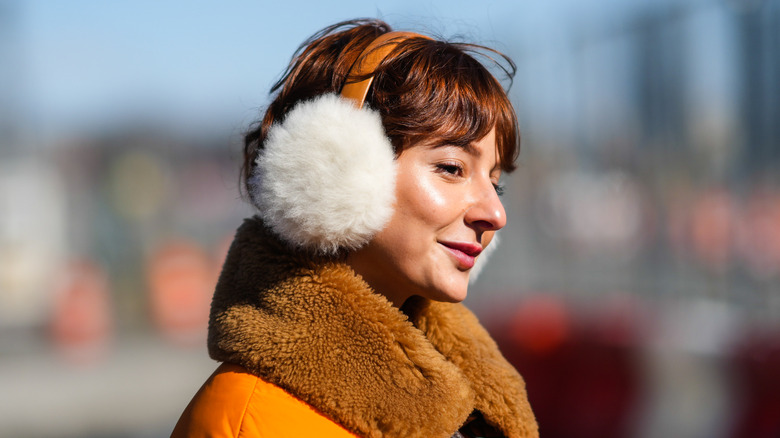 Person wearing thick coat and large earmuffs
