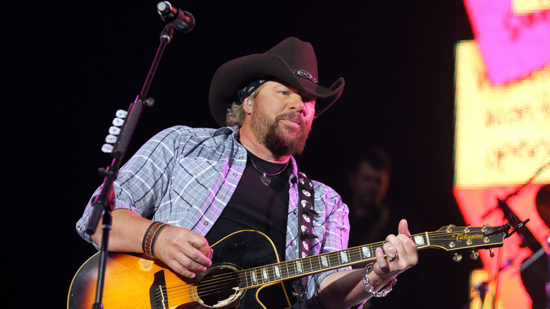 Toby Keith playing guitar on stage
