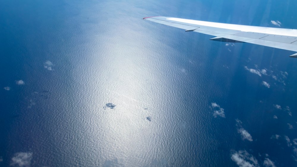Aerial view of ocean through a plane window