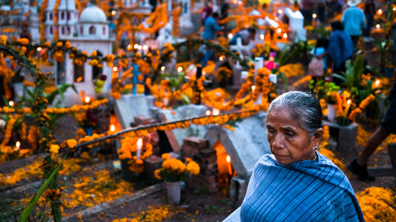 Mixtec indigenous woman walks amongst graves