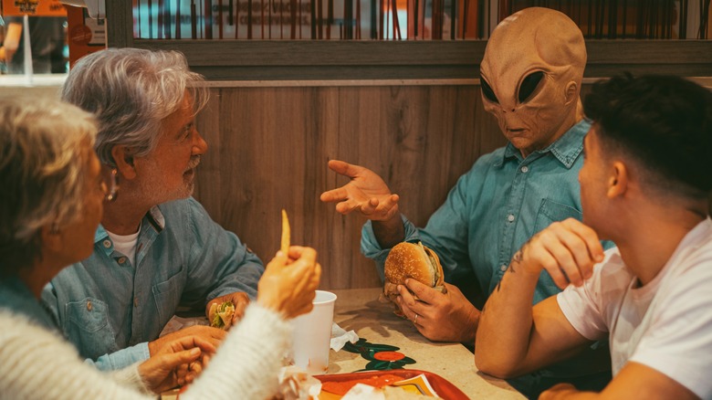 Alien eating a hamburger