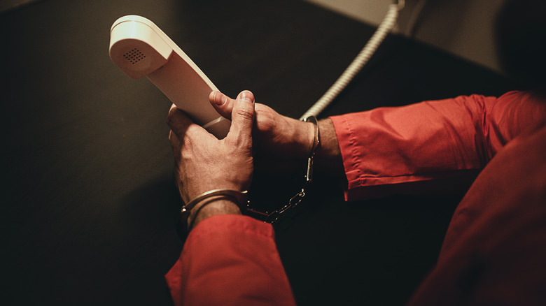 Man holding prison phone