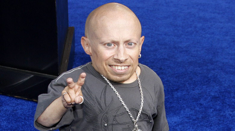 Verne Troyer giving a peace sign at an event