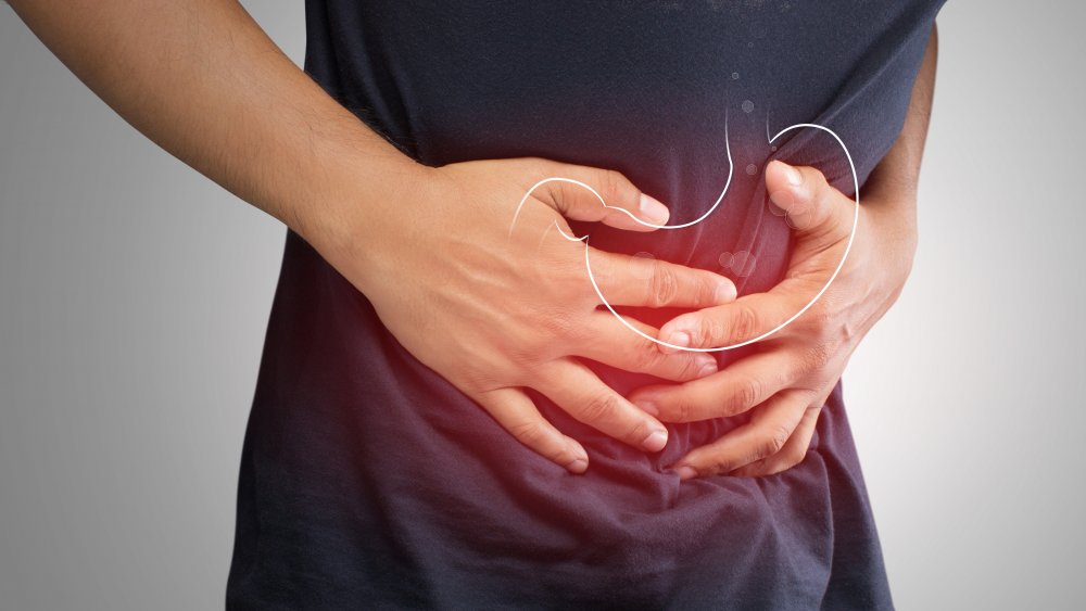 Man clutching stomach from ulcer pain
