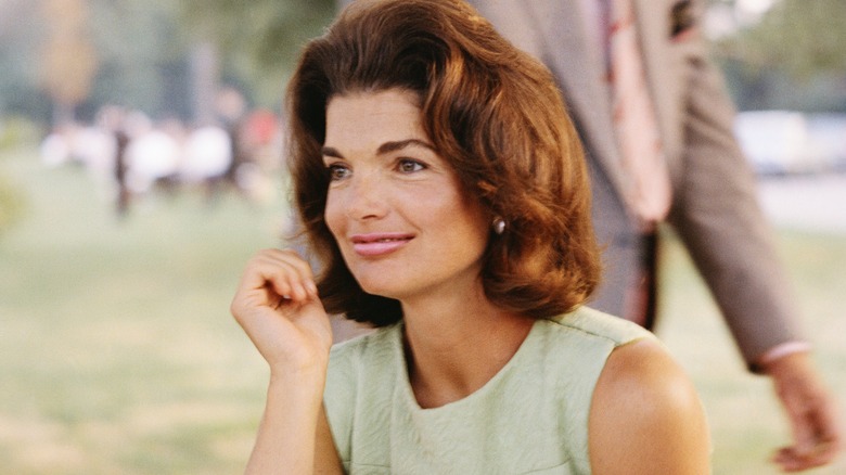 Jackie Kennedy Onassis seated and smiling