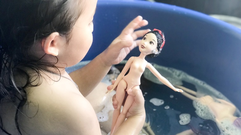 Girl in tub with doll