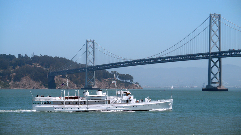 USS Potomac sails in front of bridge