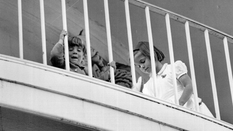 Caroline and John Jr playing on a balcony