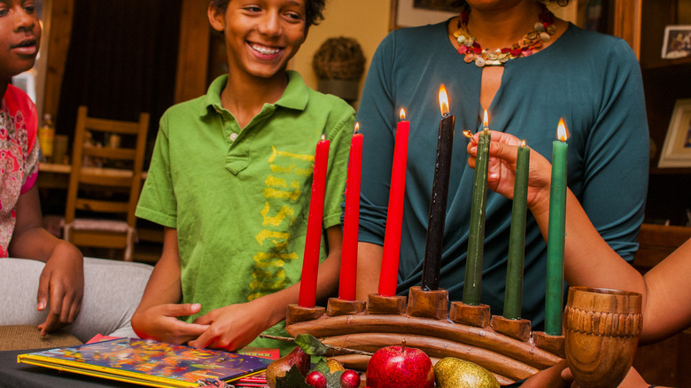 family lighting Kwanzaa candles