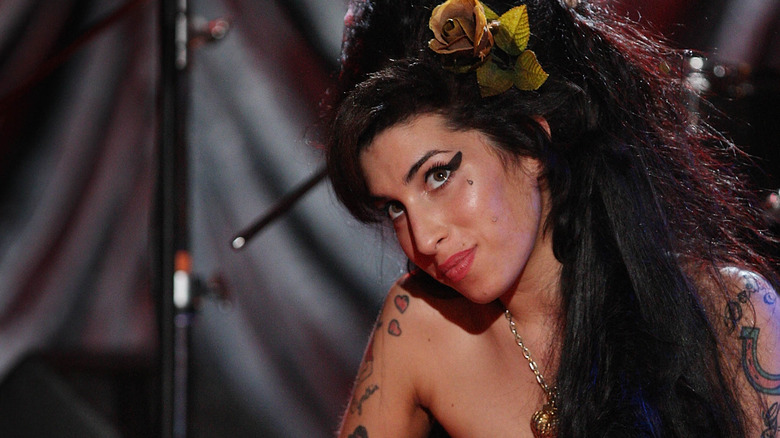 Amy Winehouse seated and looking up