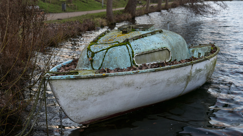 abandoned and damaged boat on shore