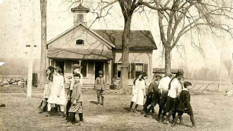 Children walking past schoolhouse