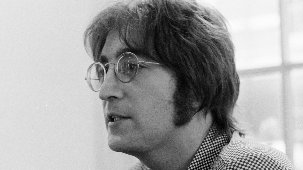 A black-and-white profile shot of John Lennon