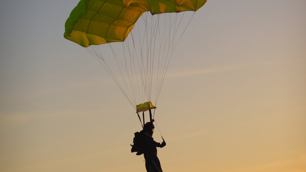Skydiver landing at sunset with reserve chute