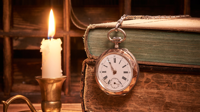 Pocketwatch, candle, and books