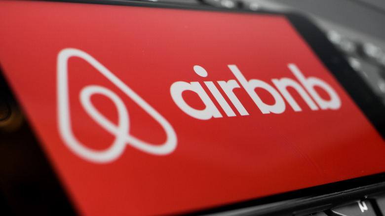 mobile phone with red airbnb logo
