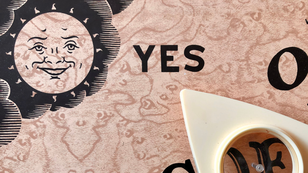 A Ouija board with the planchette pointed towards 'yes'