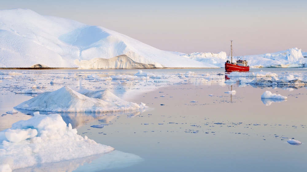 A photograph of a boat in the frozen Arctic waters near the North Pole.
