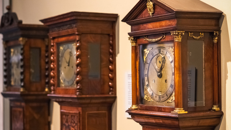Three grandfather clocks on display