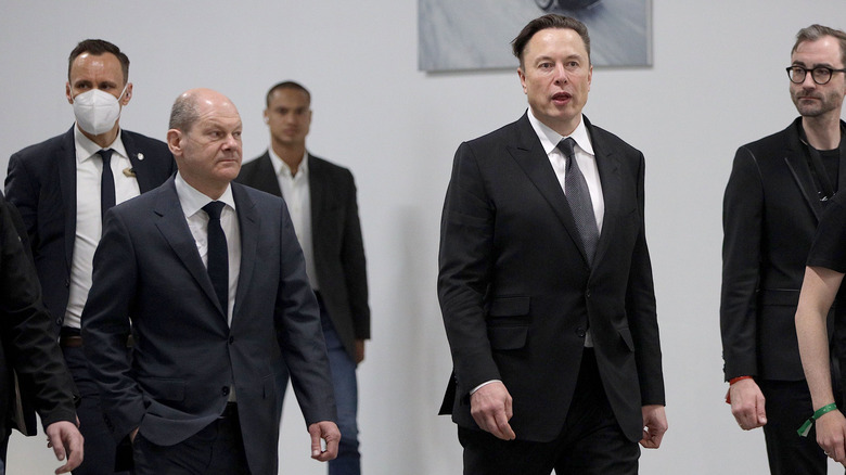 Elon Musk walking with executives