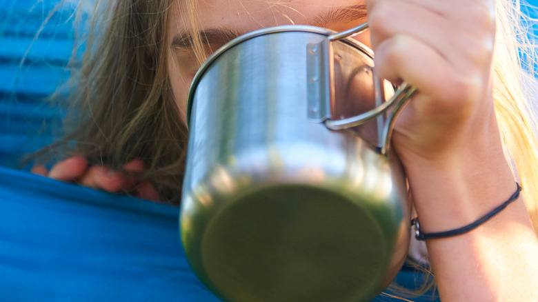 Girl drinking from tin cup