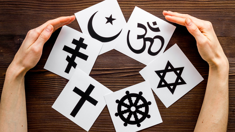 religious symbols on table hands surrounding