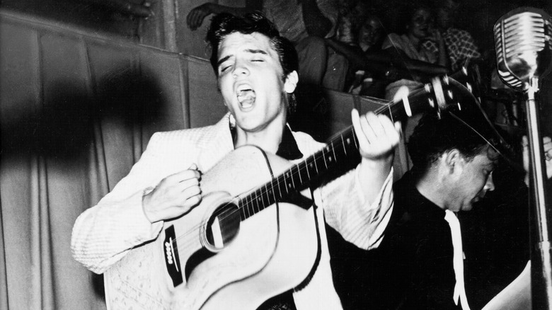 Elvis on stage with acoustic guitar