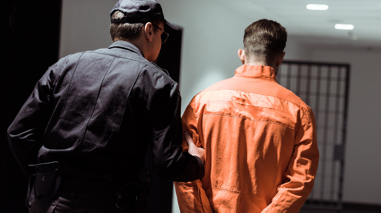 A correctional officer leading a prisoner