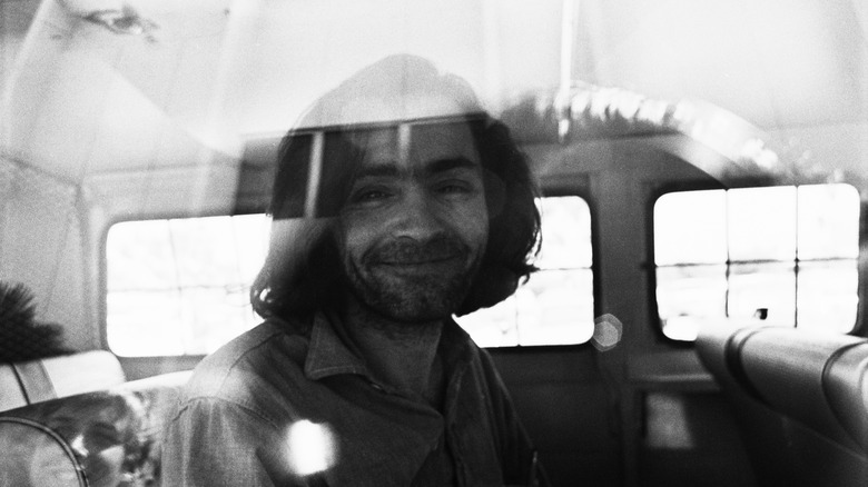 Charles Manson traveling court vehicle smiling